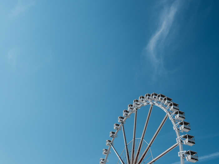 White ferris wheel with blue summer skies in the background