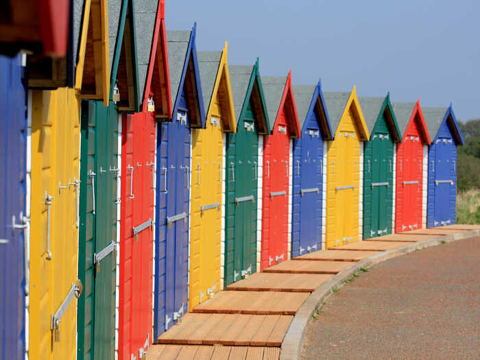 Yellow, blue, green and red beach huts along Dawlish Warren Beach